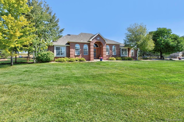 ranch-style house featuring a front yard and brick siding