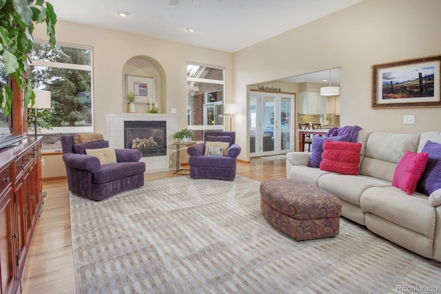 living room with a tiled fireplace, light wood finished floors, and recessed lighting