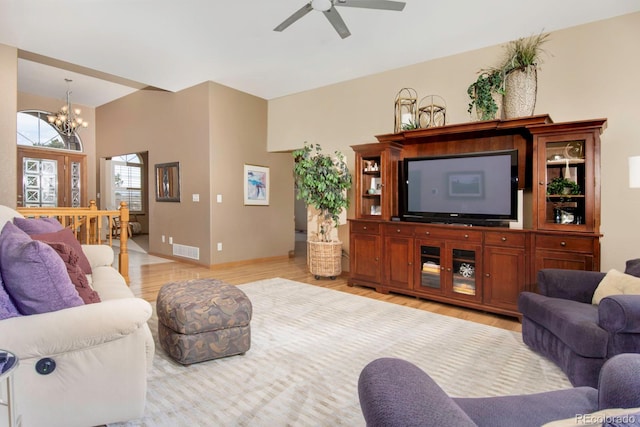 living area with visible vents, baseboards, light wood finished floors, and ceiling fan with notable chandelier