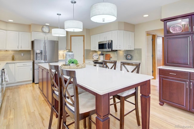 kitchen with light countertops, tasteful backsplash, a breakfast bar area, and stainless steel appliances