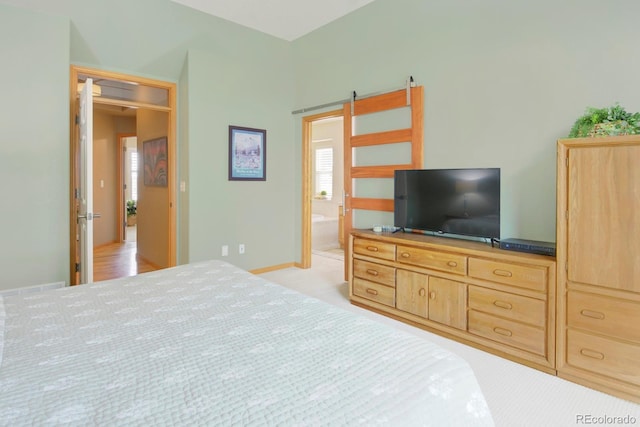 bedroom with ensuite bath and light colored carpet