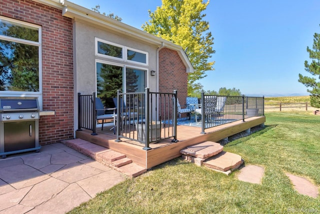 wooden deck with a yard and area for grilling
