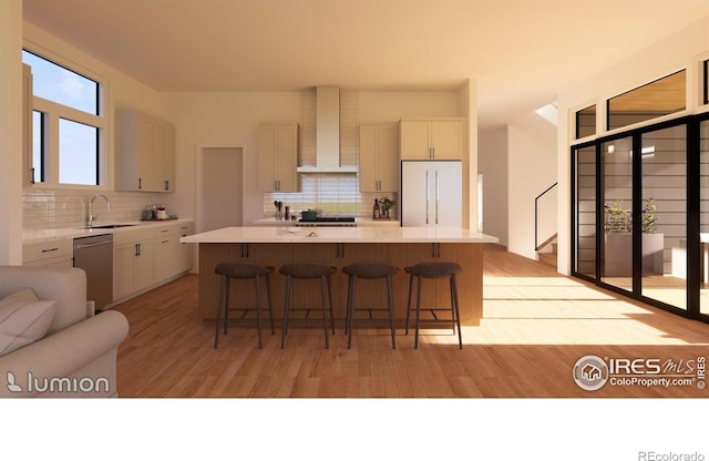 kitchen featuring a center island, white fridge, light hardwood / wood-style flooring, and wall chimney range hood