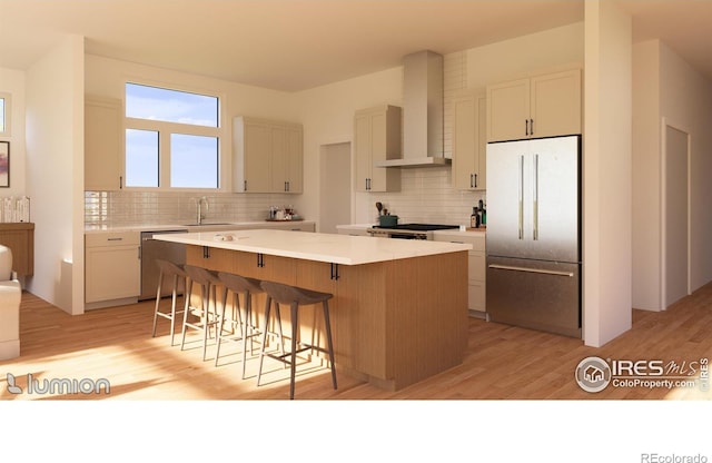 kitchen with tasteful backsplash, a center island, light hardwood / wood-style floors, wall chimney exhaust hood, and appliances with stainless steel finishes