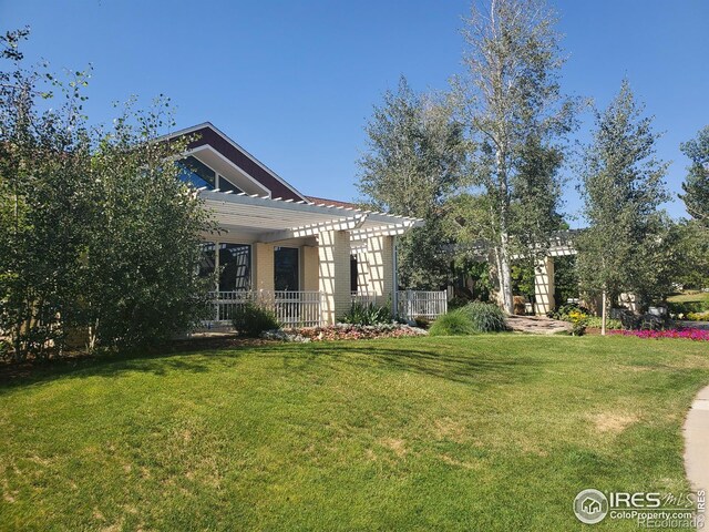 exterior space with a pergola and a lawn