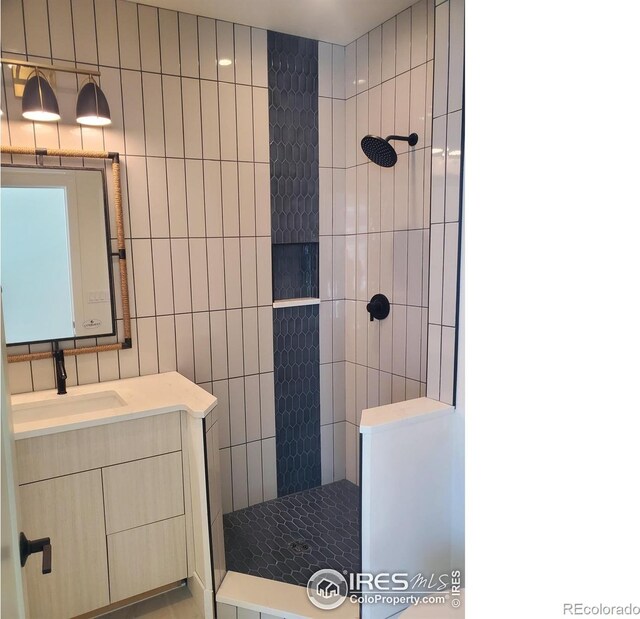 full bathroom featuring walk in shower, tile walls, and vanity