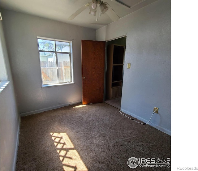 carpeted empty room featuring ceiling fan