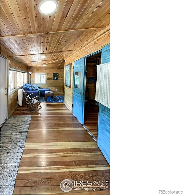 hallway with hardwood / wood-style floors, wooden ceiling, and wooden walls