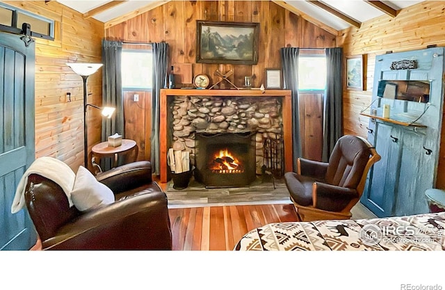 living room with vaulted ceiling with beams, wood-type flooring, wooden walls, and a fireplace