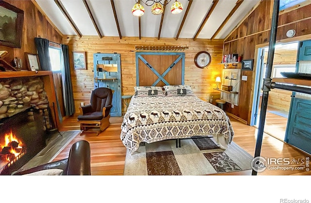 bedroom featuring vaulted ceiling with beams, light hardwood / wood-style floors, and wooden walls