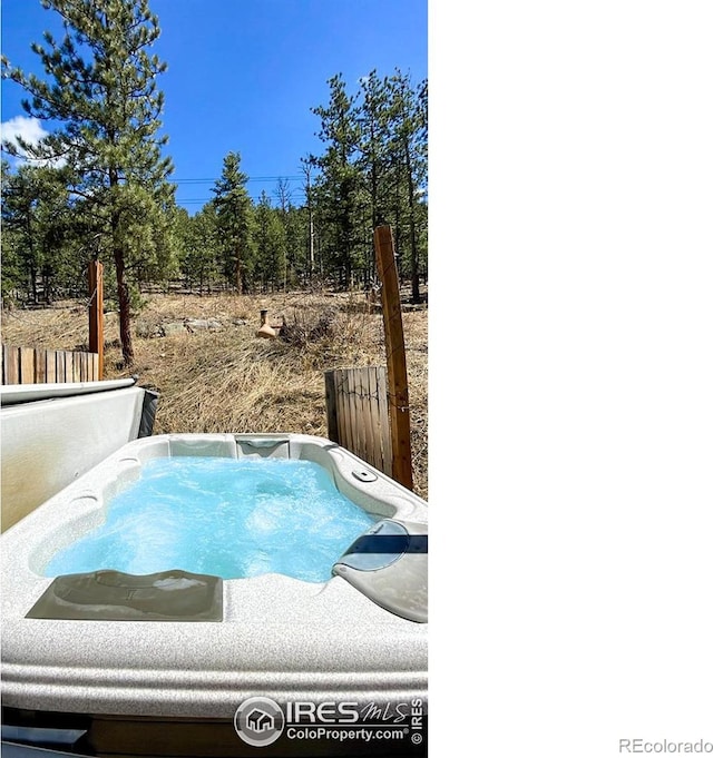 view of swimming pool featuring a covered hot tub