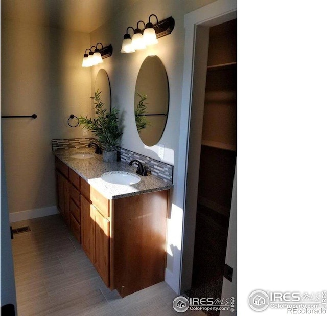 bathroom featuring vanity, backsplash, and tile patterned flooring