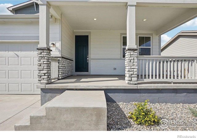 doorway to property with a garage and covered porch