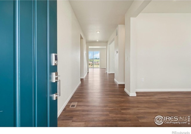 interior space with visible vents, baseboards, and dark wood-type flooring