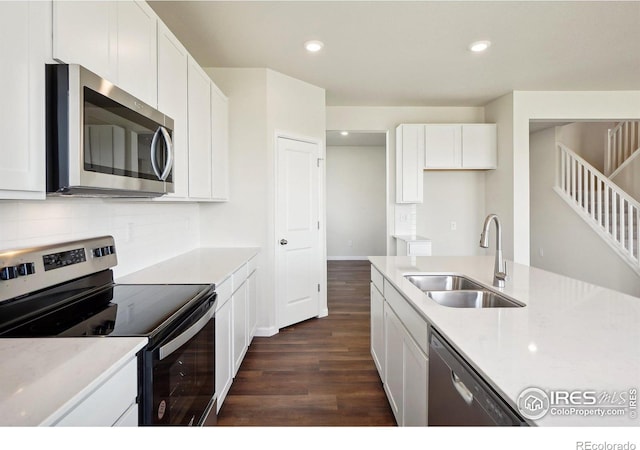 kitchen featuring a sink, backsplash, appliances with stainless steel finishes, and white cabinets