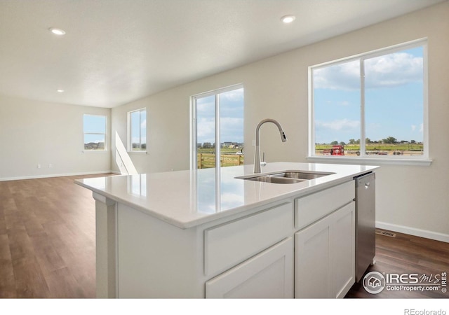 kitchen with an island with sink, a sink, dark wood finished floors, white cabinets, and dishwasher