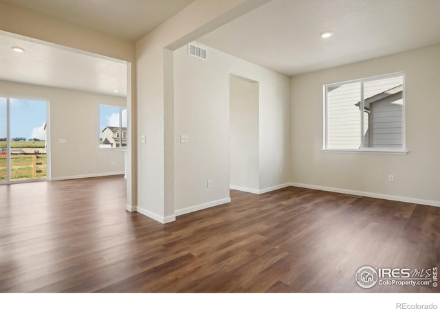 spare room featuring dark wood-style floors, visible vents, recessed lighting, and baseboards