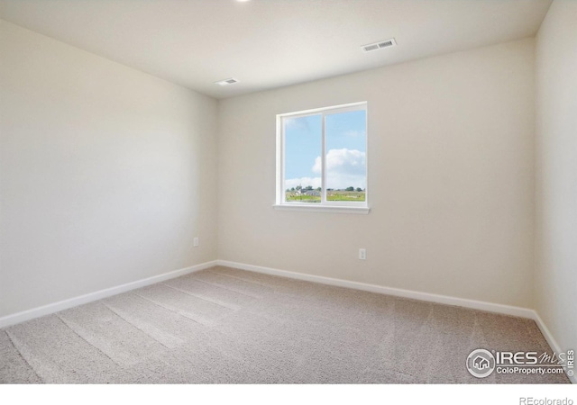 spare room with baseboards, visible vents, and carpet floors