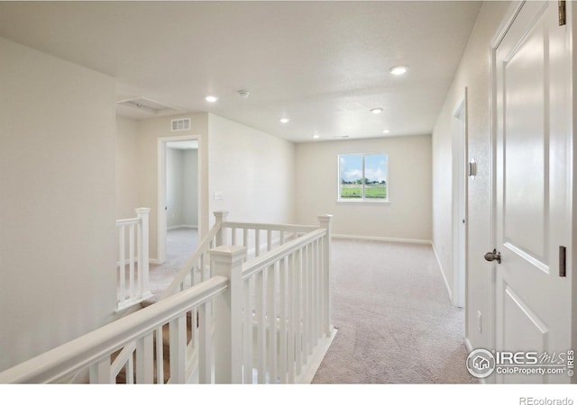 hallway featuring visible vents, baseboards, carpet, an upstairs landing, and recessed lighting