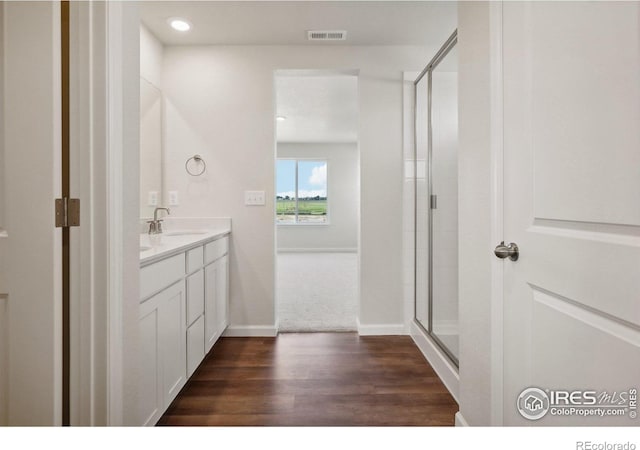 full bath with visible vents, wood finished floors, a shower stall, baseboards, and vanity