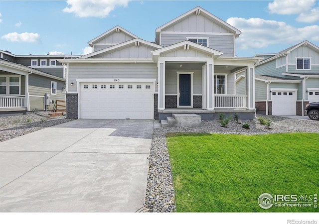 craftsman house with board and batten siding, a porch, driveway, and a front lawn