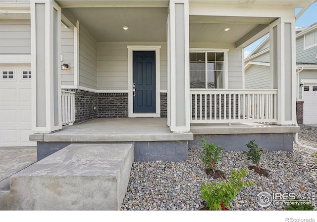 entrance to property with covered porch and brick siding