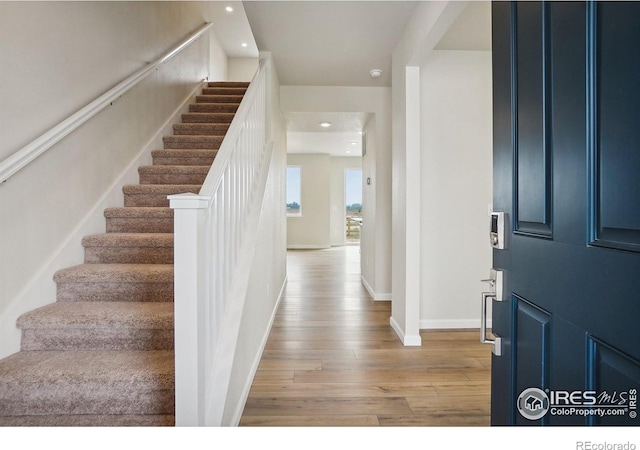 foyer entrance with light wood-style flooring, stairs, baseboards, and recessed lighting