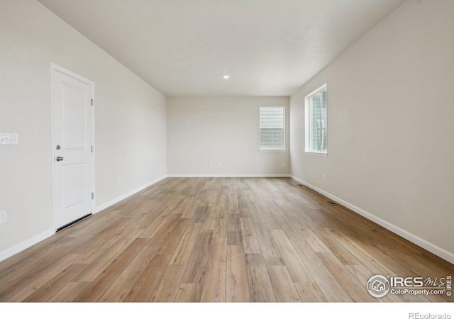 empty room with light wood-style flooring and baseboards