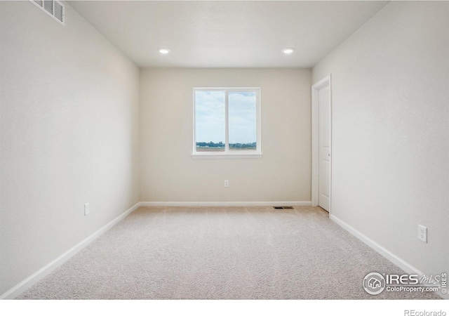 empty room with recessed lighting, light colored carpet, visible vents, and baseboards