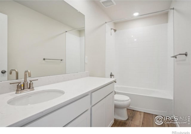 full bath featuring visible vents, toilet, shower / tub combination, wood finished floors, and vanity