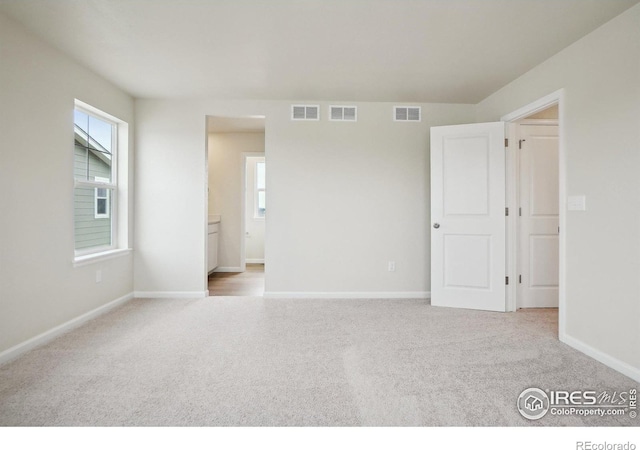 unfurnished bedroom featuring visible vents and light colored carpet