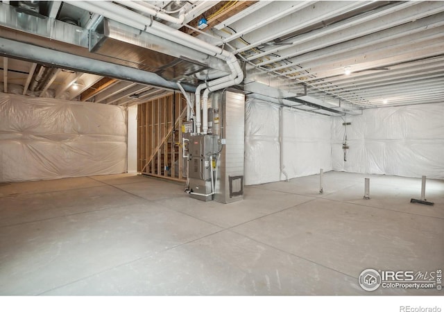 unfinished basement featuring heating unit