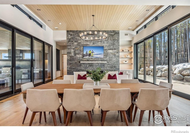 dining area featuring a notable chandelier, a towering ceiling, hardwood / wood-style floors, and wooden ceiling