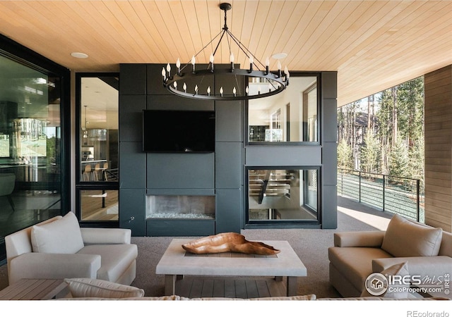 carpeted living room featuring wood ceiling, expansive windows, and a chandelier