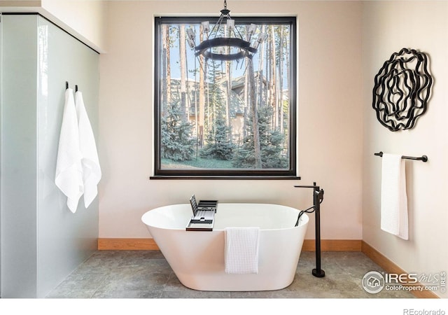 bathroom featuring a washtub and an inviting chandelier