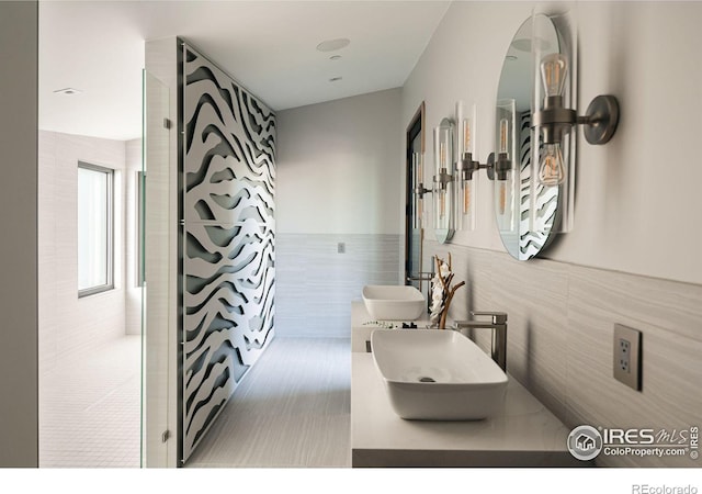 bathroom featuring sink and tile walls