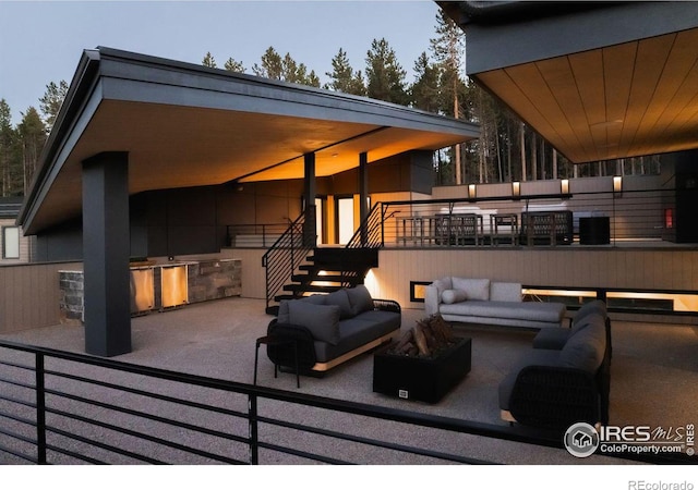 deck featuring an outdoor living space with a fire pit and a patio area