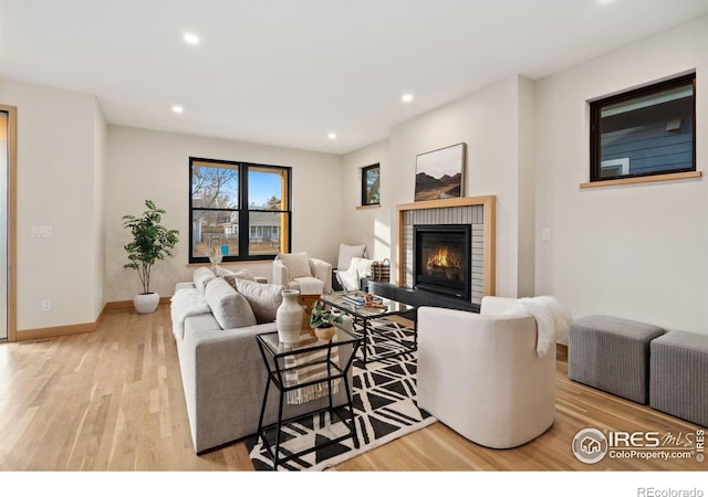 living room featuring a brick fireplace and light hardwood / wood-style floors