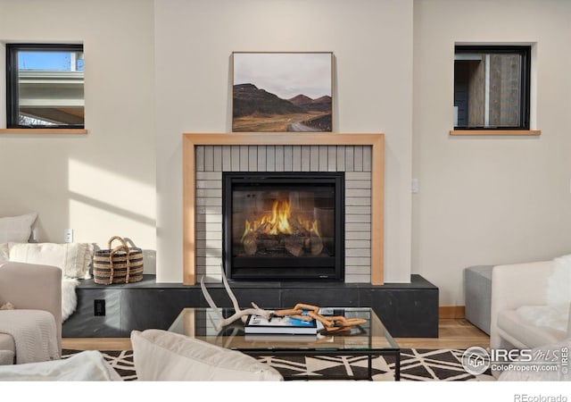 living room featuring hardwood / wood-style floors and a brick fireplace