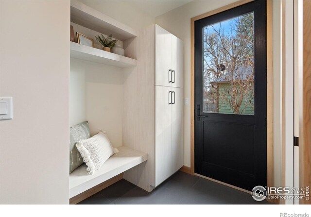 mudroom featuring dark tile floors