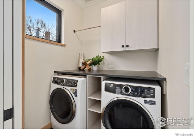 laundry room featuring cabinets and washing machine and dryer