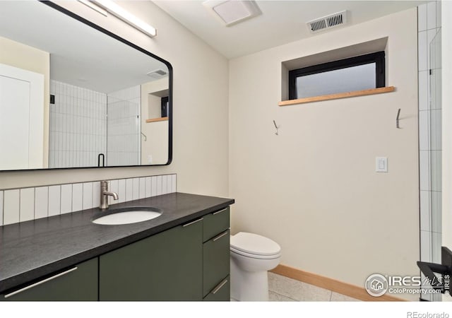 bathroom featuring tile flooring, toilet, and vanity