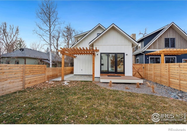 rear view of property with a pergola and a lawn