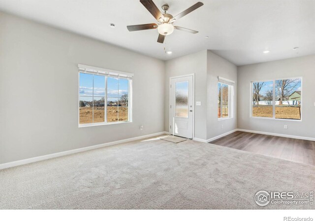 spare room featuring plenty of natural light, carpet flooring, and ceiling fan