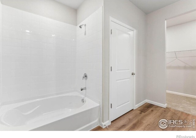 bathroom featuring tiled shower / bath combo and wood-type flooring