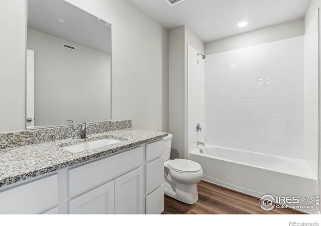 full bathroom featuring shower / bath combination, wood-type flooring, vanity, and toilet