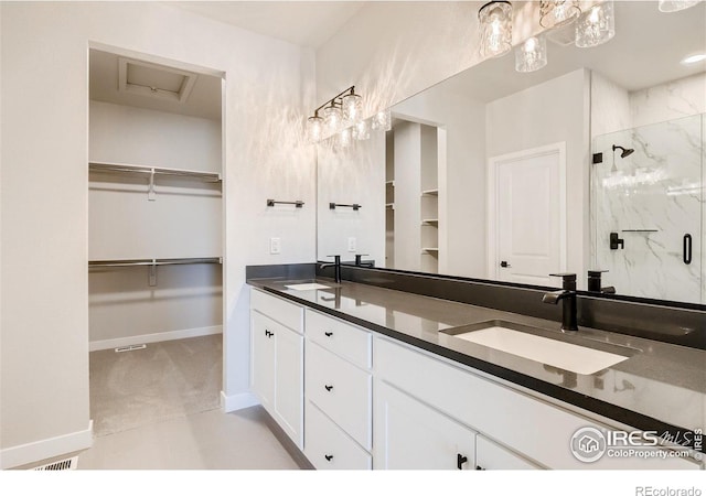 bathroom with an enclosed shower, tile floors, vanity with extensive cabinet space, and double sink