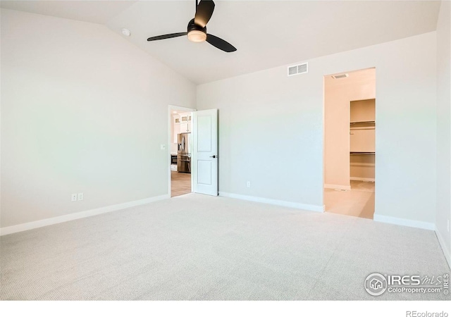 unfurnished bedroom with a spacious closet, ceiling fan, and light carpet