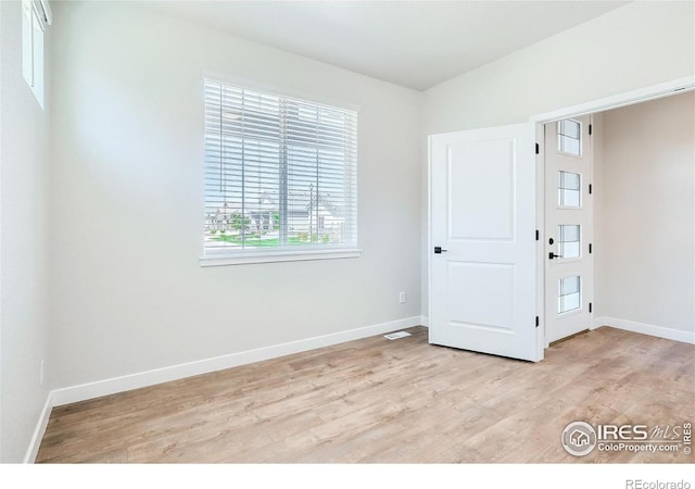 empty room with light hardwood / wood-style flooring