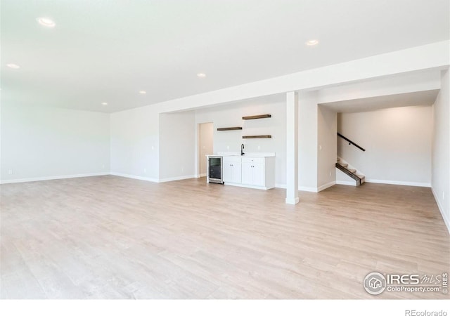 unfurnished living room with sink and light wood-type flooring